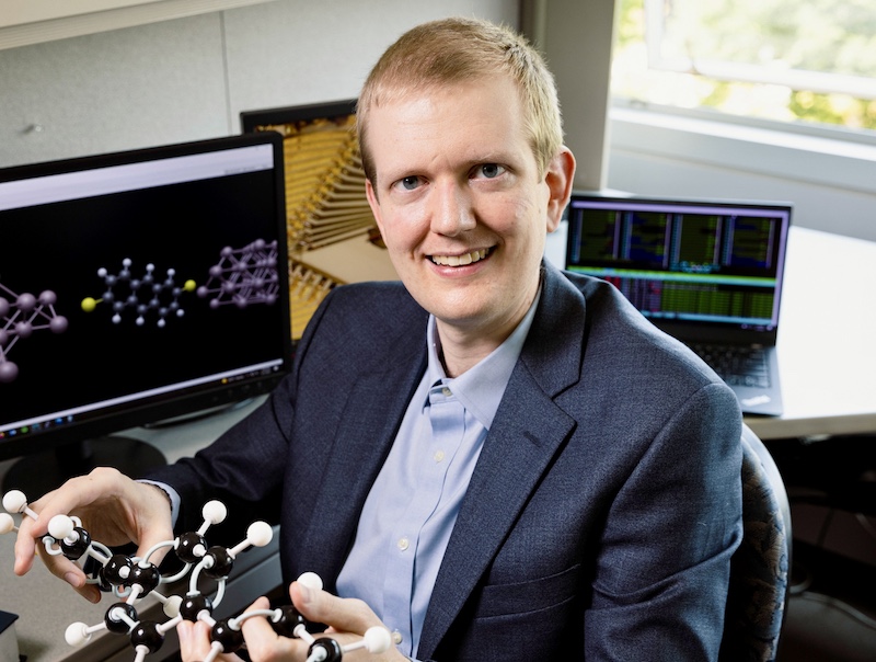 Portrait of Erik Hoy holding a molecular model
