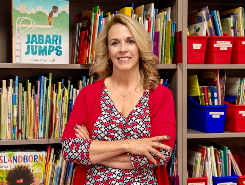 Person standing in front of children’s bookshelves at Rowan University classroom space.