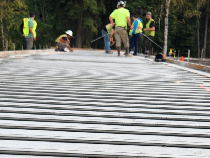 A team of researchers posing on a road being constructed with a heat system