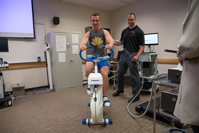 Dr. Dankel works with a student on a stationary bike